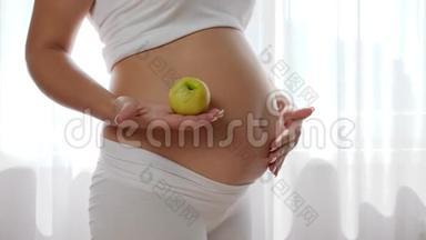 怀孕期间的营养和饮食，肚子里有宝宝的女人手里拿着绿苹果